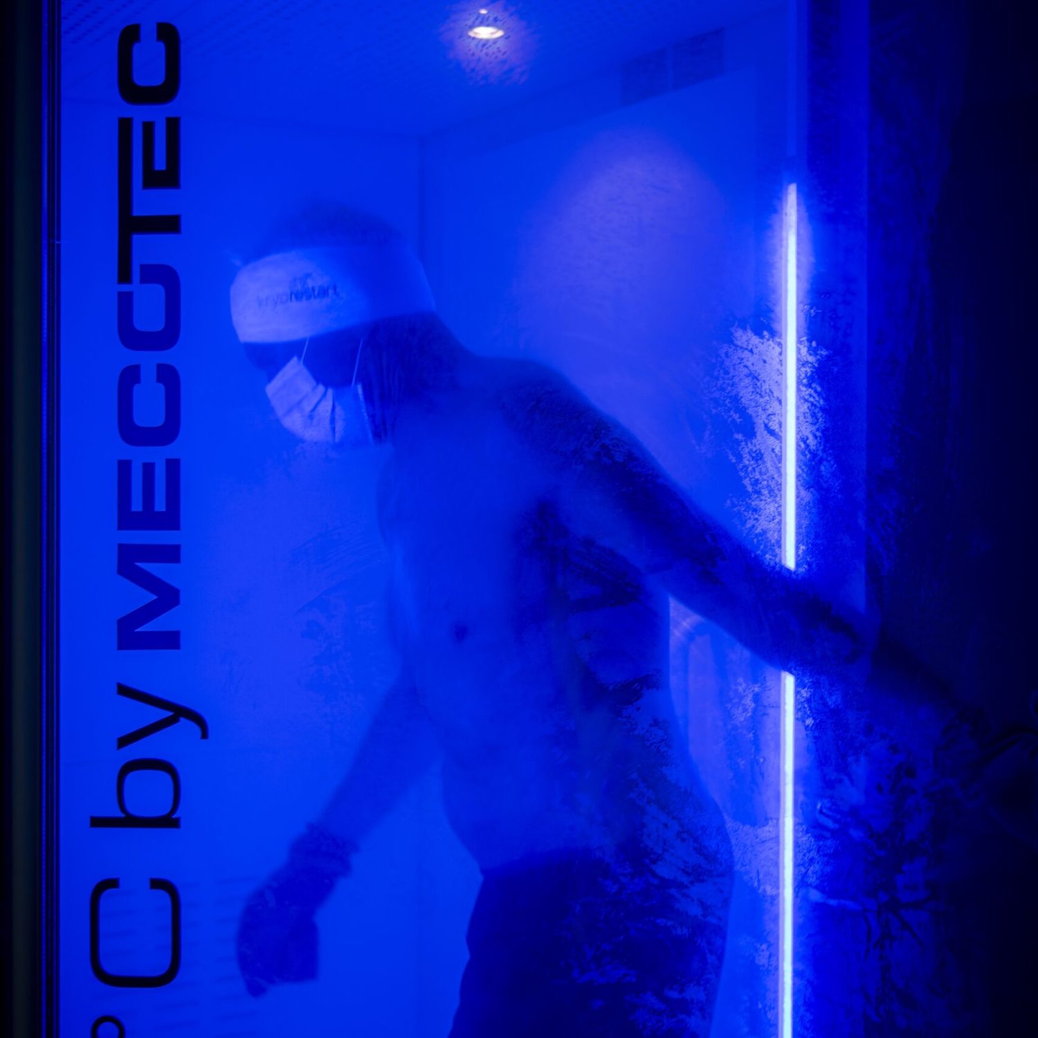 Osoba v modře osvětlené kryokomoře (nápis MECOTEC)